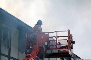 Brandweer slaat bovenste ramen in v.d. loods